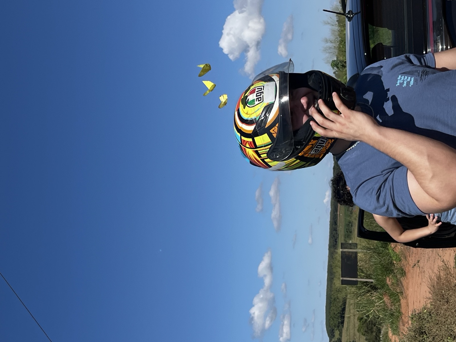 Person mit Motorradhelm auf einem Feldweg