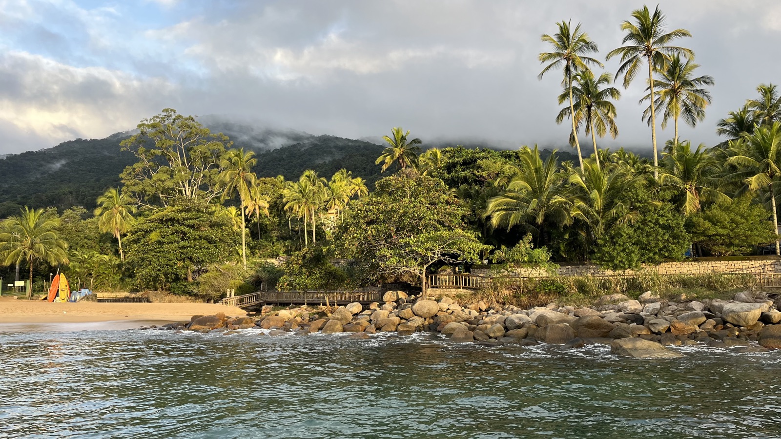 Palmenstrand mit Blick auf bewaldete Berge