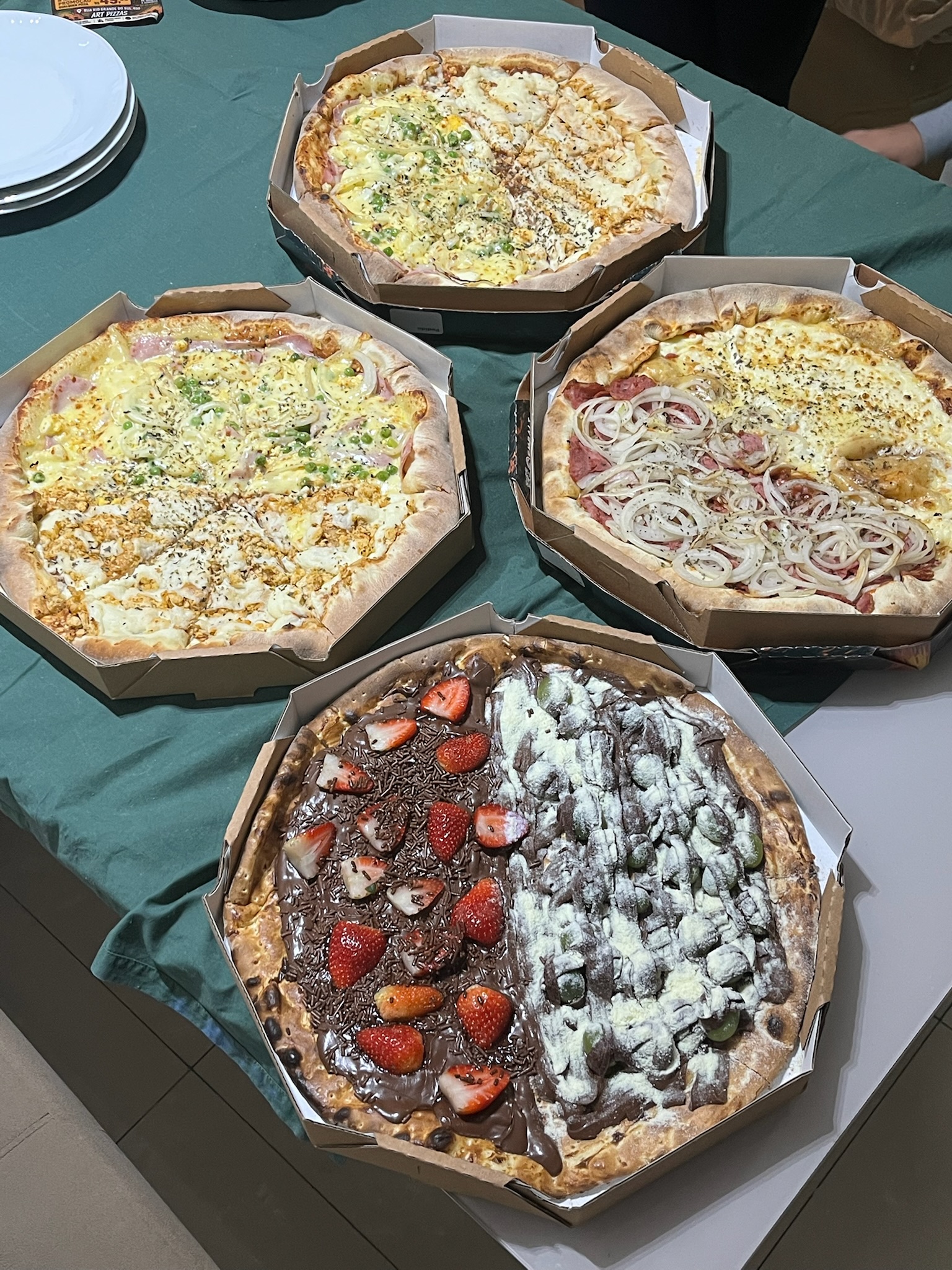 Süße Pizza mit Erdbeeren und Schokolade neben herzhaften Pizzen